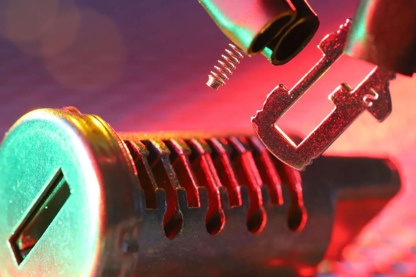 Close-up of a lock cylinder and key during a rekeying job, pin chambers exposed